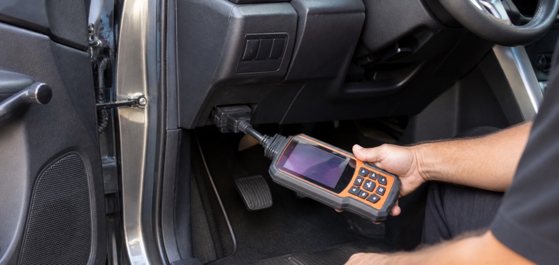 OBD programming tool plugged into a diagnostic port in Orlando, Florida.